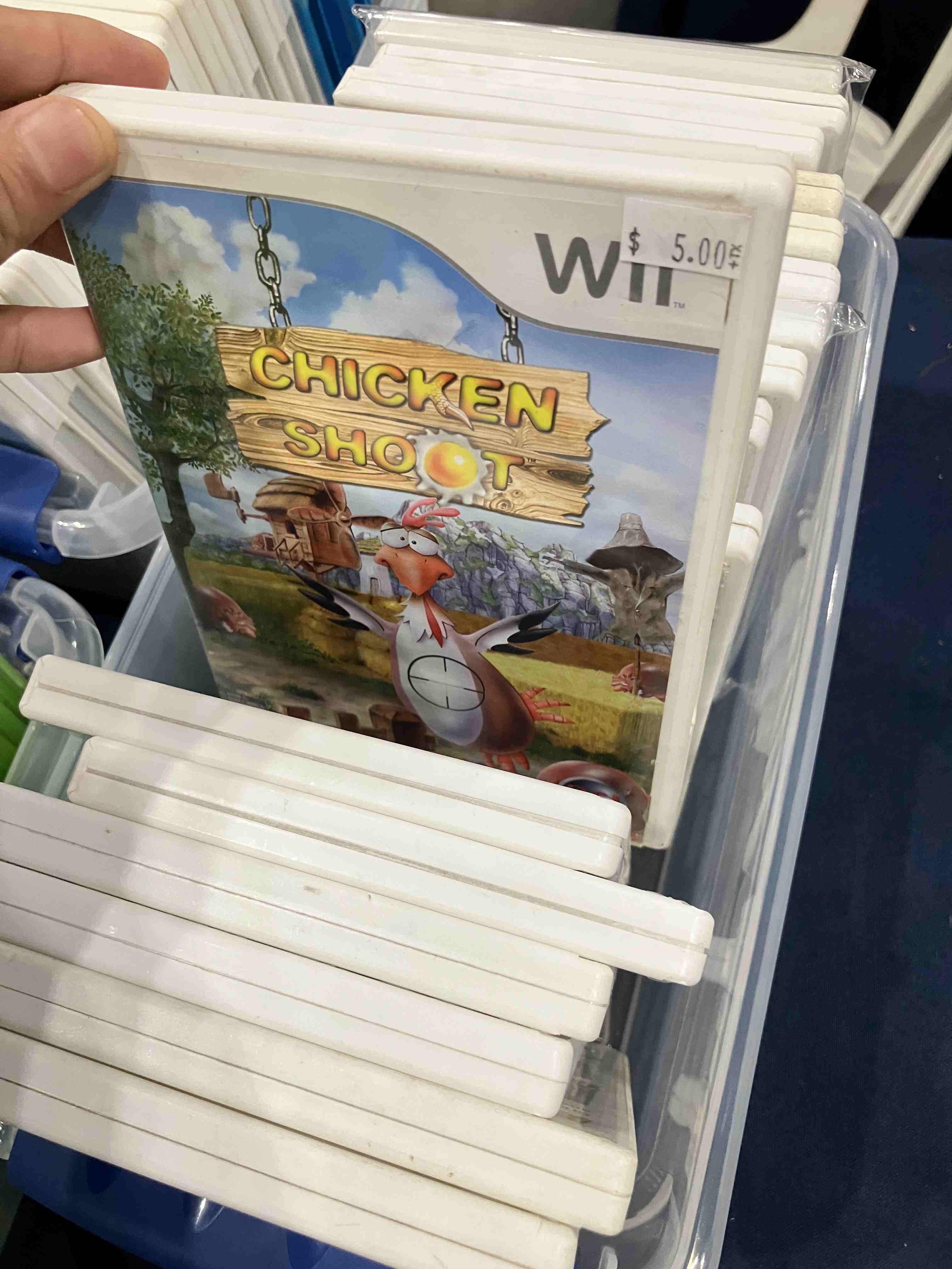The front cover of a Wii game titled Chicken Shoot. Illustrated is a chicken with a crosshair aiming towards its chest. This game is considered shovelware