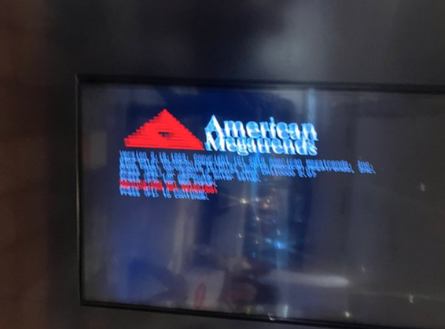 A display at a mall showing the American Megatrends Power on and Self Test screen. Something had failed to pass during startup according to the screen, but the picture is too blurry to tell what went wrong.